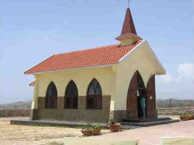 The yellow Alto Vista Chapel with white cross